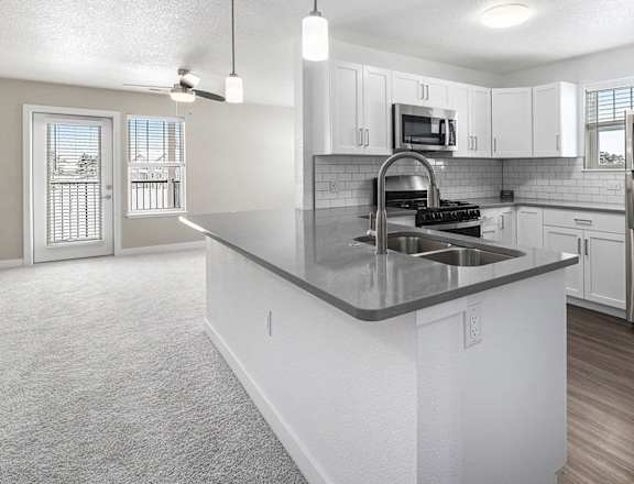 A modern kitchen with stainless steel appliances and white cabinets at Eagle Ridge Apartment Homes in Traverse City, MI
