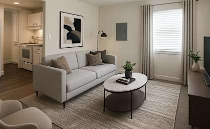 A modern living room with a white sofa, a grey armchair, and a coffee table.