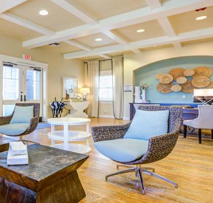 A living room with a wooden floor and a large painting on the wall.