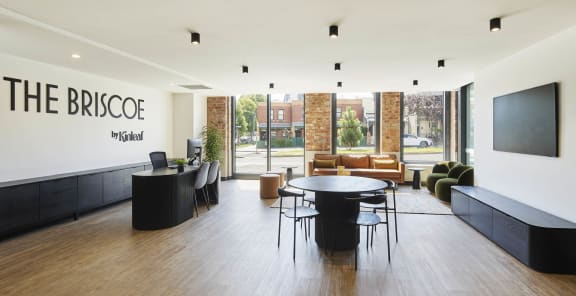 a seating area with tables and chairs on a balcony