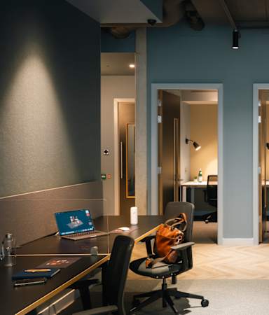 A modern office space with desks, chairs, and computers.
