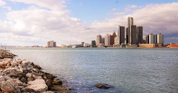 A city skyline is reflected in the water.