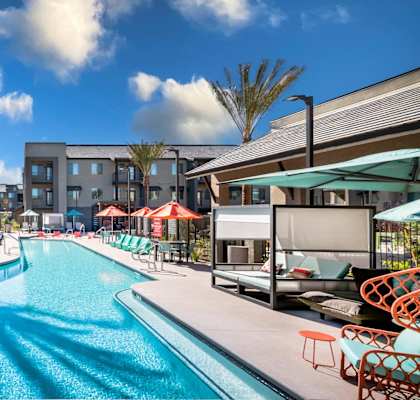 a swimming pool with lounge chairs and umbrellas