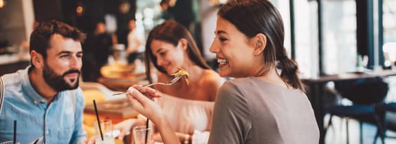 a group of people sitting at a table eating food