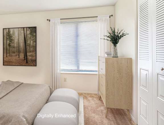 A bedroom with a bed, nightstand, and a painting on the wall at West Wind Apartments, Fort Wayne, IN