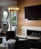 a living room with chairs and a table and a fireplace
