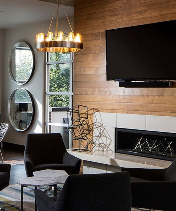 a living room with chairs and a table and a fireplace
