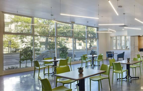 a dining room with tables and chairs and large windows