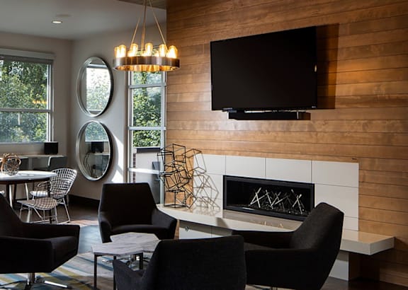 a living room with chairs and a table and a fireplace