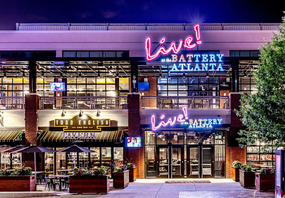 A neon sign that says "Lev'l" is lit up at night.