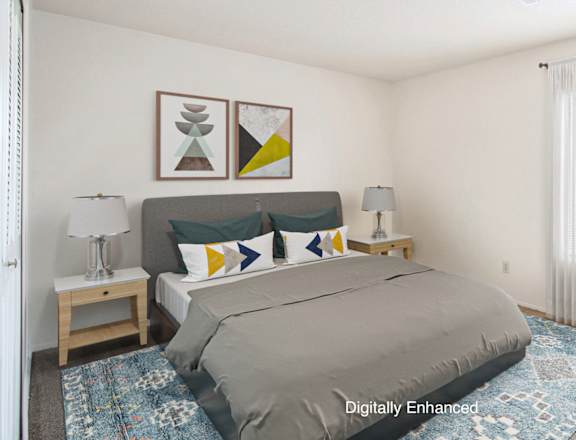 A bedroom with a bed, chair, and two lamps
