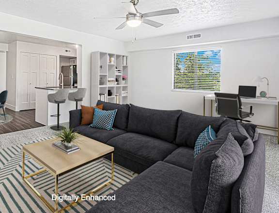 A living room with a grey sofa and a coffee table at Green Ridge Apartments, Grand Rapids, MI