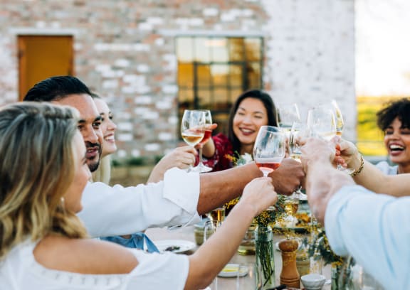 a group of people sitting around a table with wine glasses