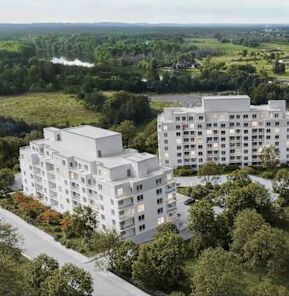 A modern white building is situated by a river in a green landscape.