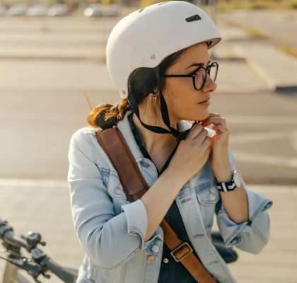 a woman wearing a helmet is standing next to a bike at Tanana Apartments, North Pole, Alaska