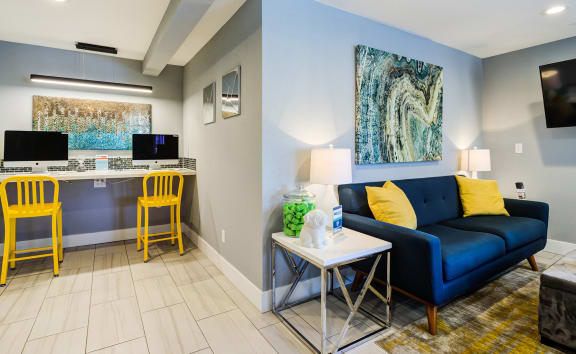 a living room with a blue couch and yellow chairs  at The Clubhouse at Port Orchard, Port Orchard, Washington