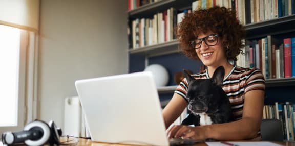 a woman working on her laptop with her dog sitting on her lap at Fountainhead, Jacksonville, FL, 32258