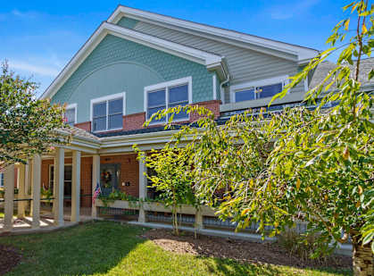 A house with a blue roof and a white fence.