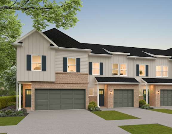 A modern house with a large front yard and multiple garages.