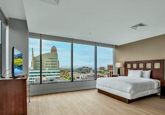 A bedroom with a large bed and a view of the city.