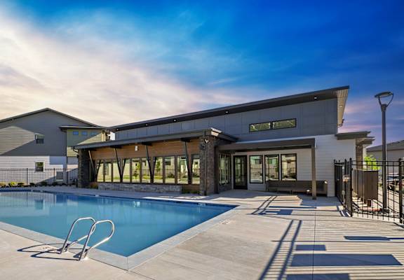 A modern house with a swimming pool in front.