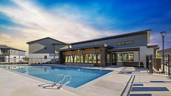 A modern house with a swimming pool in front.
