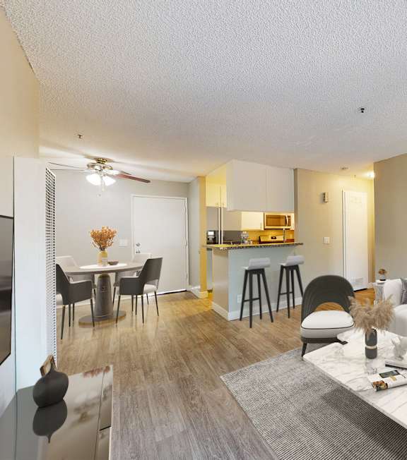 A well-lit, modern kitchen and living room with a dining area.