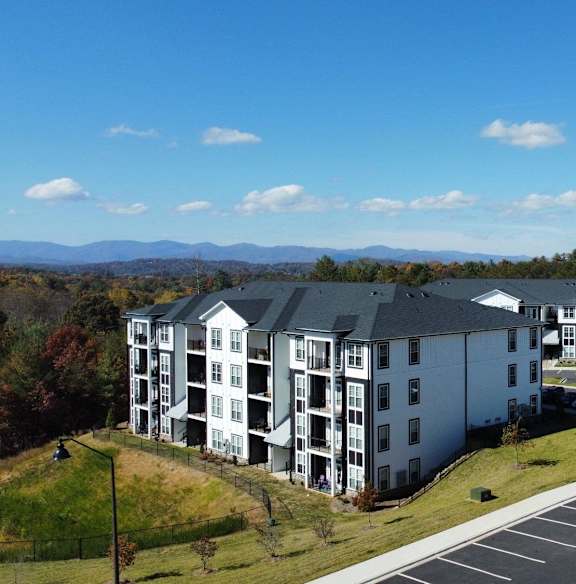 A large white building with a parking lot in front of it.