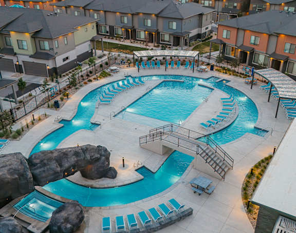 Large blue pool with a slide at H2O Townhomes, Utah