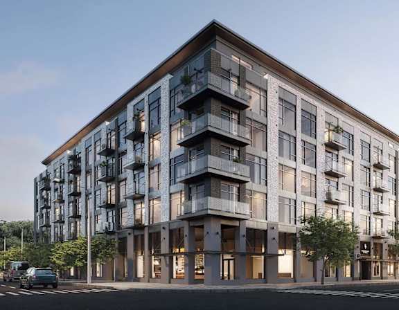 A modern multi-story building with balconies and large windows.