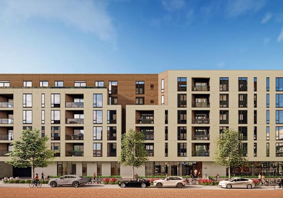 A modern apartment building with cars parked in front.