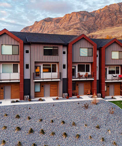 A row of modern houses with a mountain in the background.