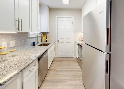 A kitchen with white cabinets and a granite countertop. at Breckinridge Vue, Duluth, 30096