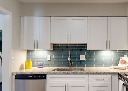 A kitchen with white cabinets and a black stove top oven. at Vinings RiverVue, Atlanta, GA