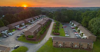 an aerial view of a parking lot and buildings at sunset
