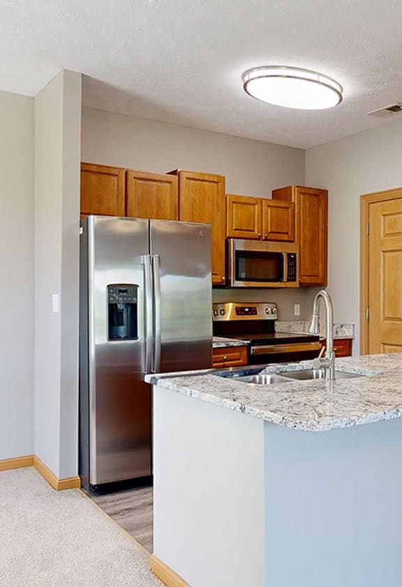 a kitchen with a granite counter top and a stainless steel refrigerator