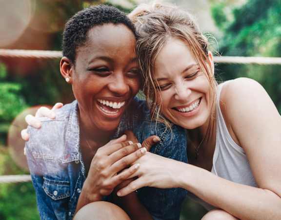Two Women Laughing and Embracing Each Other