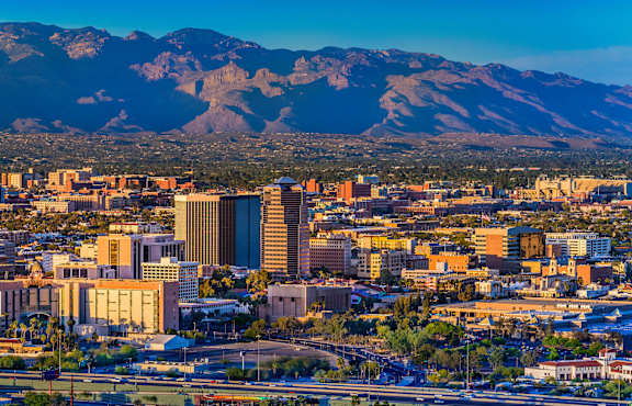 A cityscape with buildings and mountains in the background.