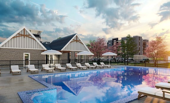 A pool area with a house and chairs.