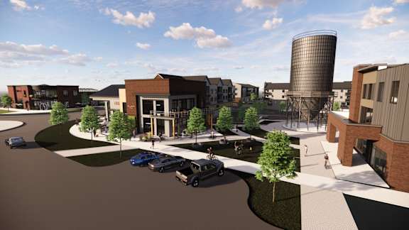 A rendering of a modern building complex with a parking lot in front.