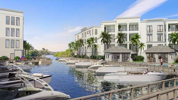 A row of houses with boats in front of them.