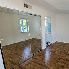 A room with wooden floors and a sliding glass door.