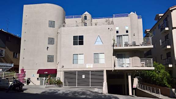 A building with a red awning and a white sign on it.