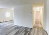Thumbnail 6 of 8 - the living room and dining room of an empty apartment with wood floors and white walls
