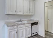 Thumbnail 4 of 8 - a kitchen with white cabinets and a sink and a dishwasher