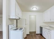 Thumbnail 3 of 8 - a kitchen with white cabinets and a stove and a refrigerator