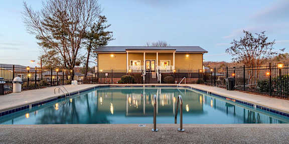 a swimming pool with a house in the background