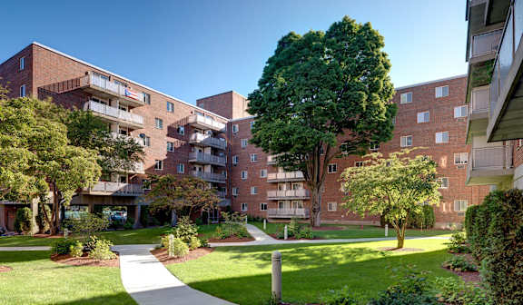 A large red brick building with a walkway in front of it at Edmands House, Framingham, 01701