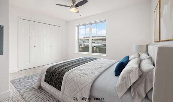 A bedroom with a large bed and a ceiling fan.