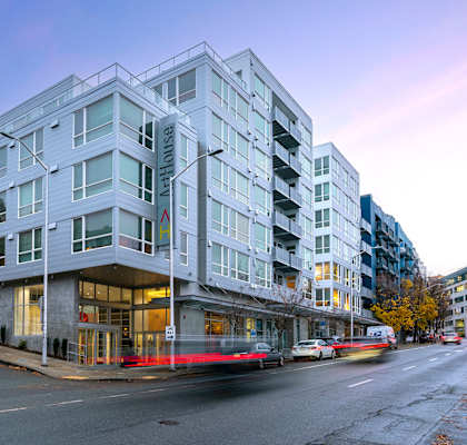 A modern apartment building with cars parked in front.